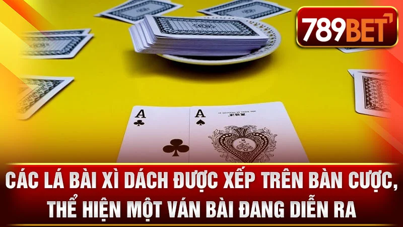 Các lá bài Xì Dách được xếp trên bàn cược, thể hiện một ván bài đang diễn ra.