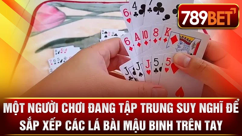 Một người chơi đang tập trung suy nghĩ để sắp xếp các lá bài Mậu Binh trên tay.